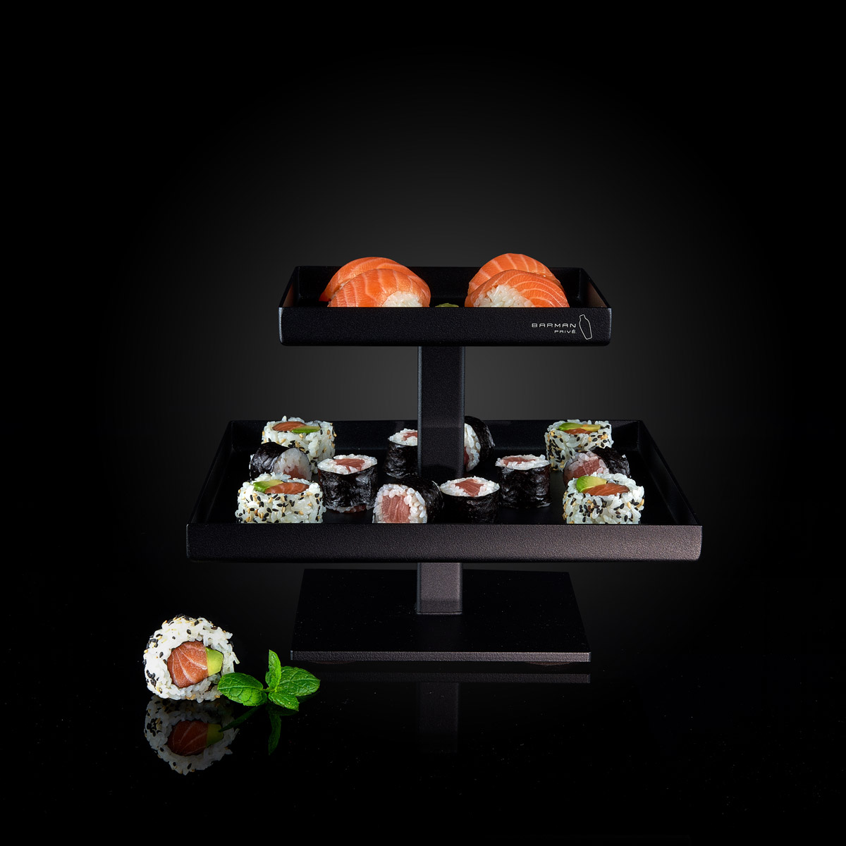 Présentoir de sushis sur fond noir.